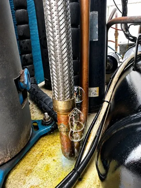 Close up of a commercial refrigeration compressor and pipework during a service