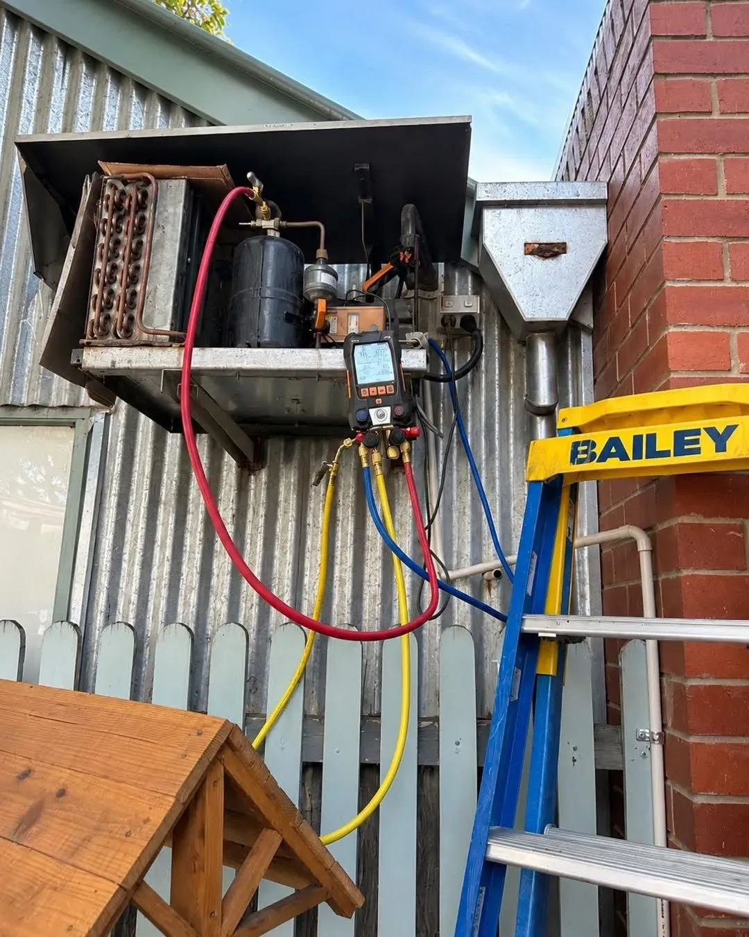 Commercial refrigeration condensing unit being diagnosed with a digital gauge manifold